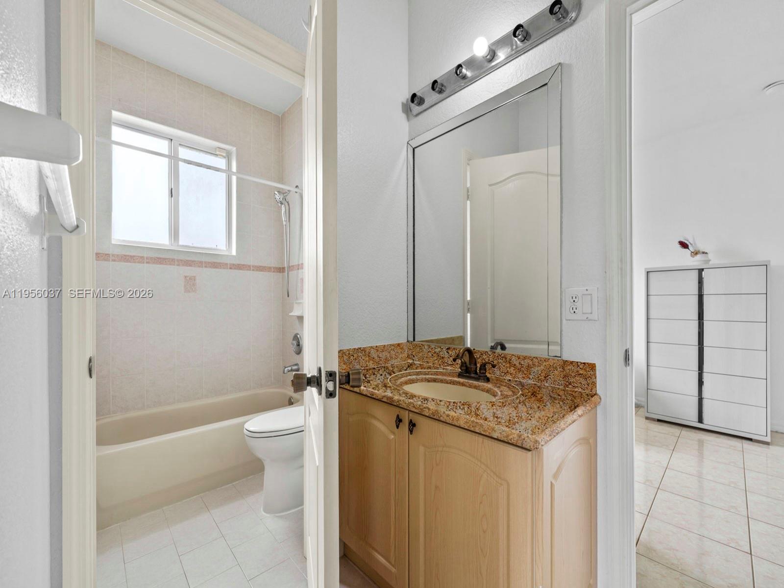 15383 Southwest 23rd Street Miami, FL 33185 - Photo 22 of 36 a bathroom with a granite countertop sink a toilet and shower