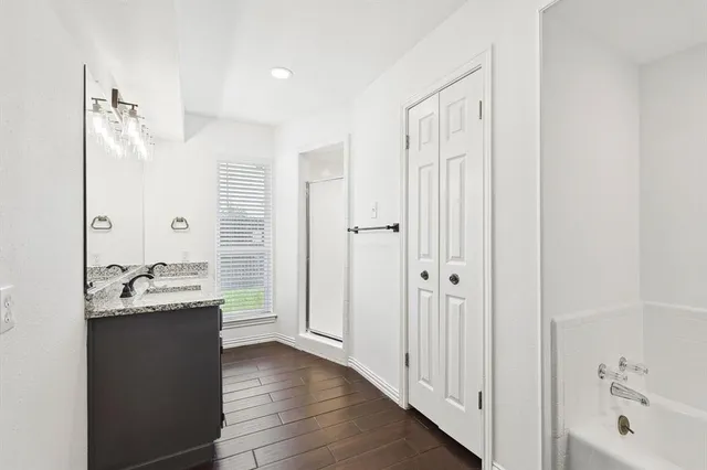 a bathroom with a tub sink and mirror