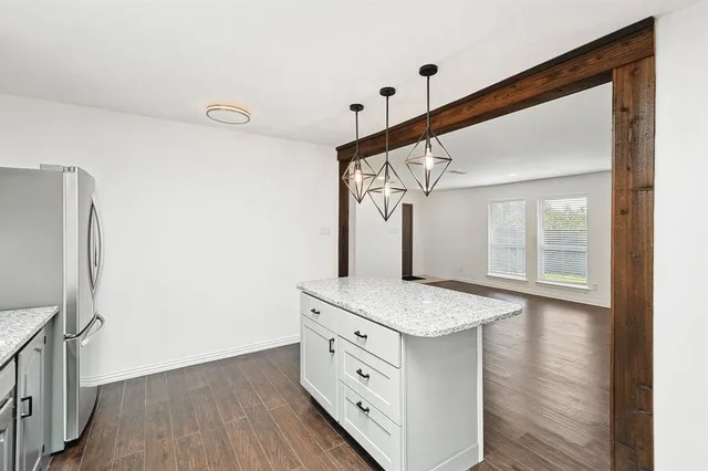 a kitchen with cabinets and wooden floor