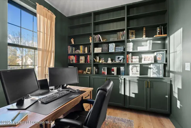 a view of a workspace with furniture and a window