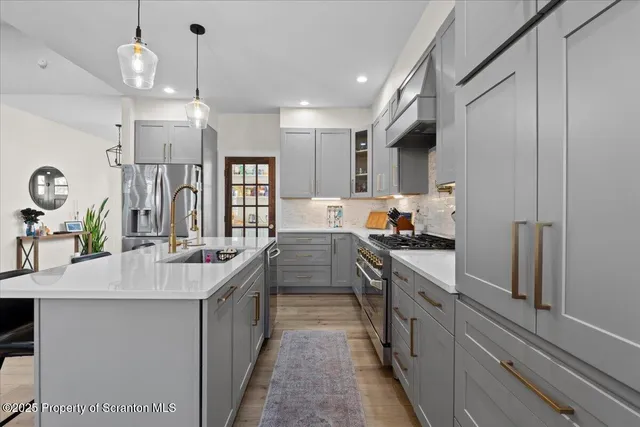 a kitchen with stainless steel appliances a sink stove and refrigerator