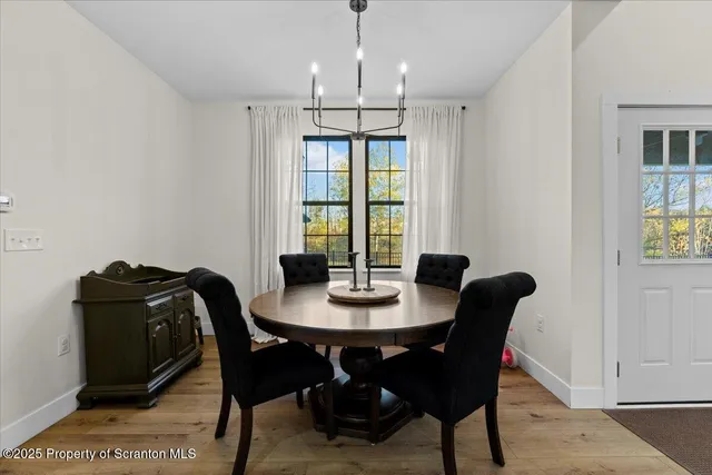 a kitchen with stainless steel appliances kitchen island granite countertop a refrigerator a stove a oven a dining table and chairs with wooden floor