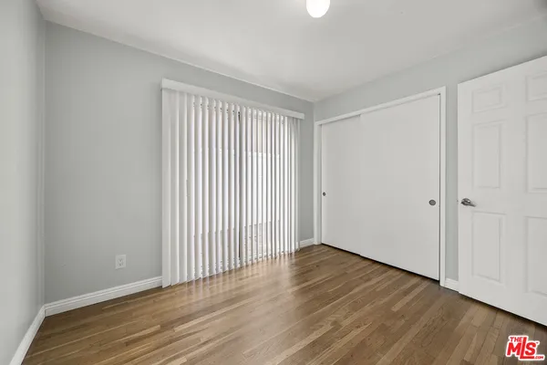 a view of an empty room with wooden floor
