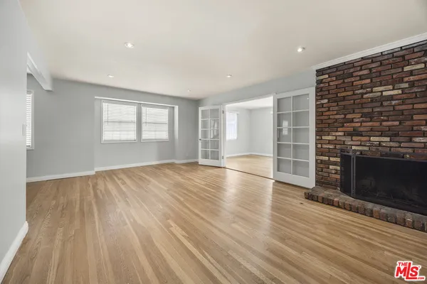 an empty room with wooden floor and fireplace
