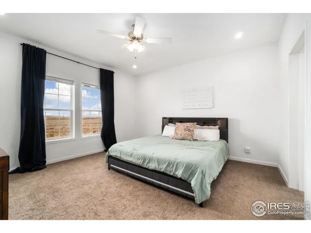 a spacious bedroom with a bed and a chandelier