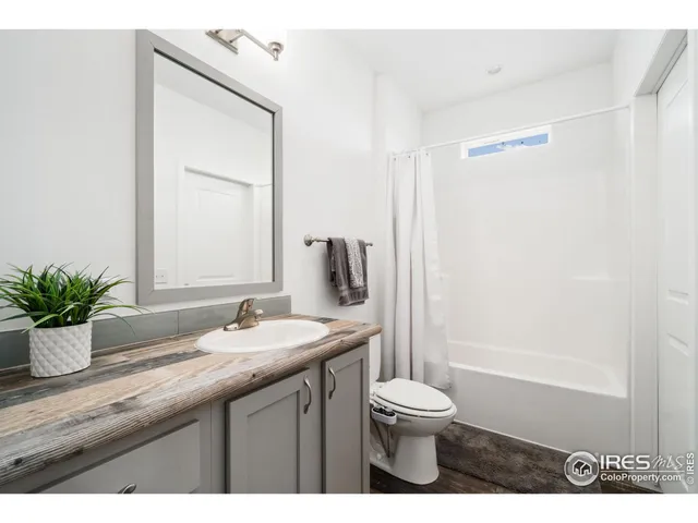a bathroom with a granite countertop sink toilet a large mirror and shower