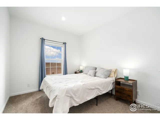 a bedroom with a bed table and a window
