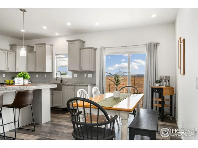 a dining hall with stainless steel appliances kitchen island a table and chairs
