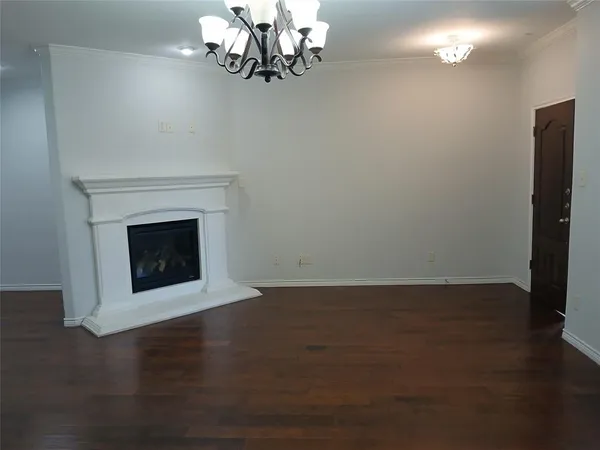 an empty room with wooden floor and stairs
