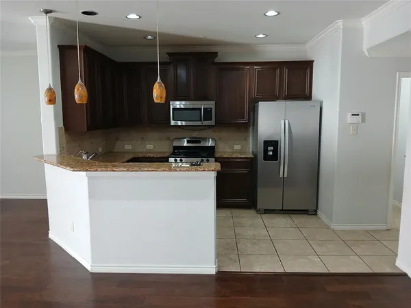a kitchen with stainless steel appliances granite countertop a stove a sink and a microwave