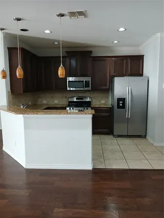 a kitchen with stainless steel appliances granite countertop a refrigerator a stove a sink and dishwasher
