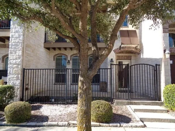 a view of a brick house with many windows next to a road