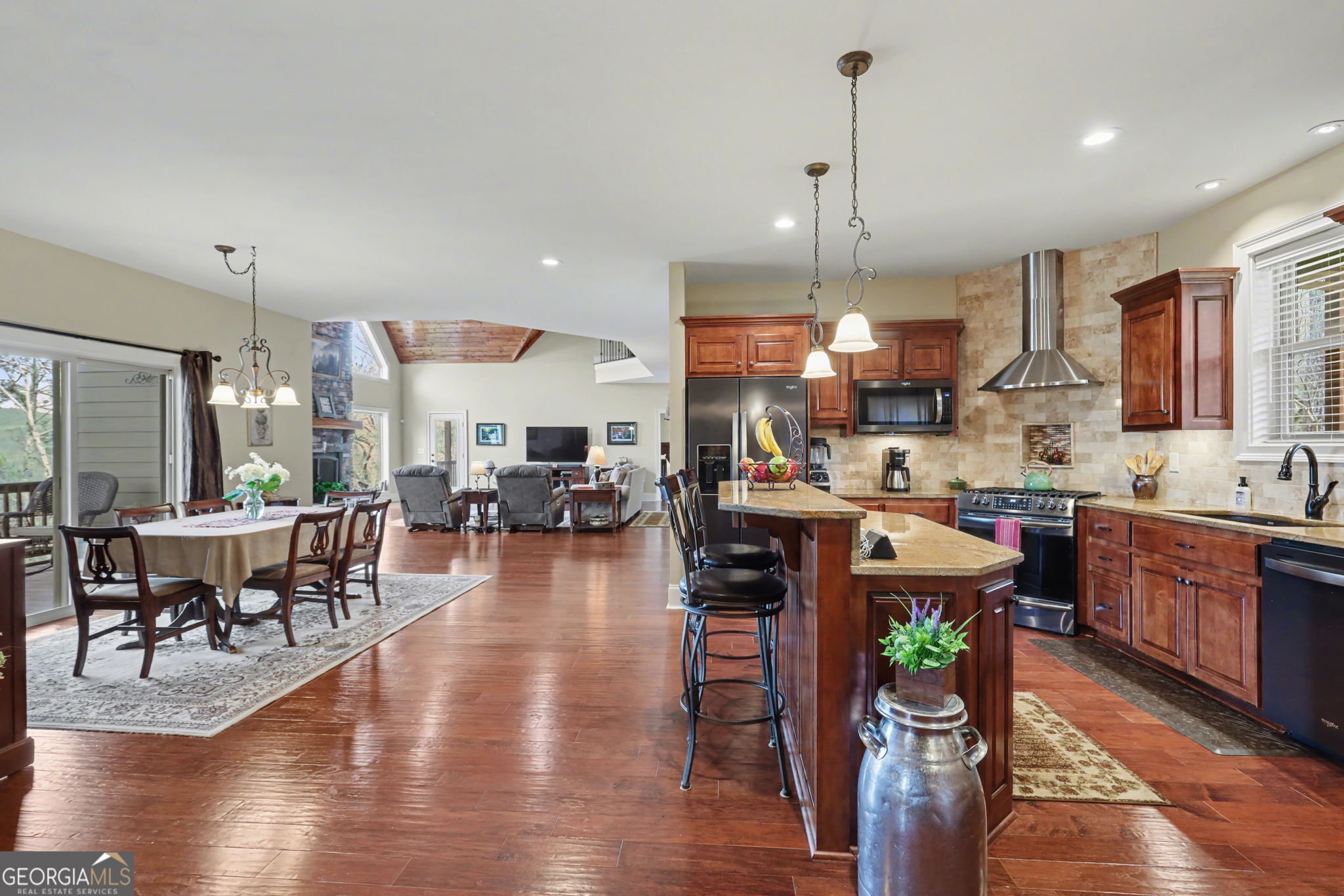 421 Hickory Nut Mountain Road Tallulah Falls, GA 30573 - Photo 48 of 117 a open kitchen view with stainless steel appliances granite countertop a stove a refrigerator a kitchen island a dining table and chairs with wooden floor