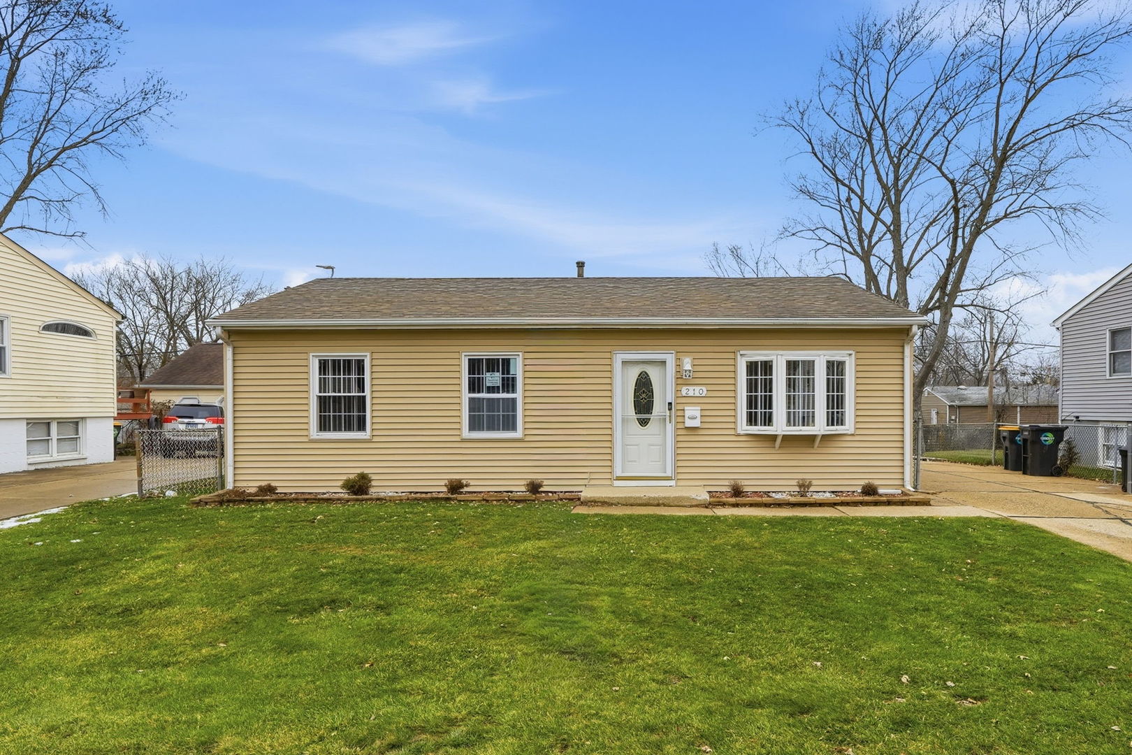 a front view of house with yard and trees in the background