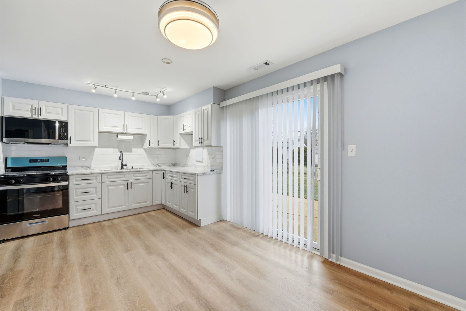 210 Willow Road Streamwood, IL 60107 - Photo 16 of 26 a kitchen with granite countertop a sink stainless steel appliances and cabinets