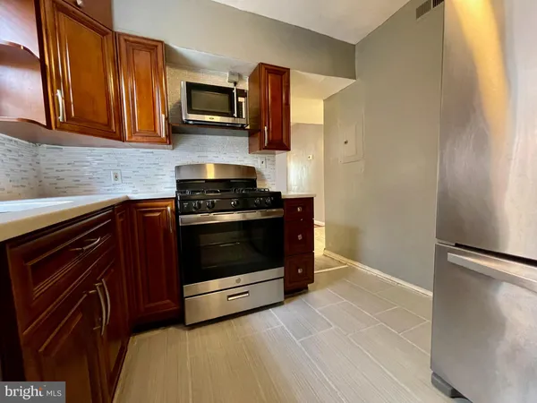 a kitchen with stainless steel appliances granite countertop a stove microwave and refrigerator