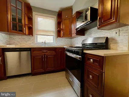 a kitchen with stainless steel appliances granite countertop wooden cabinets and a stove top oven