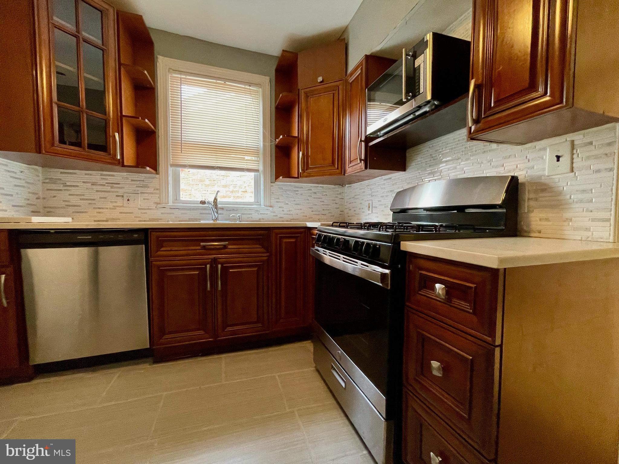 1858 Kendall Street Northeast, Unit 2 Washington, DC 20002 - Photo 30 of 38 a kitchen with stainless steel appliances granite countertop wooden cabinets and a stove top oven