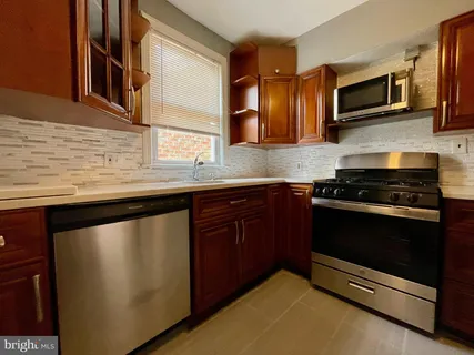 a kitchen with stainless steel appliances granite countertop a stove microwave and sink