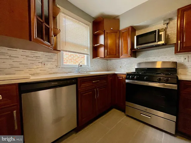a kitchen with stainless steel appliances granite countertop a stove microwave and sink