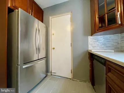 a metallic refrigerator freezer sitting inside of a kitchen