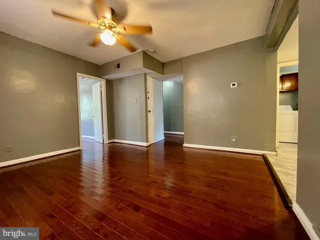 a view of an empty room with wooden floor