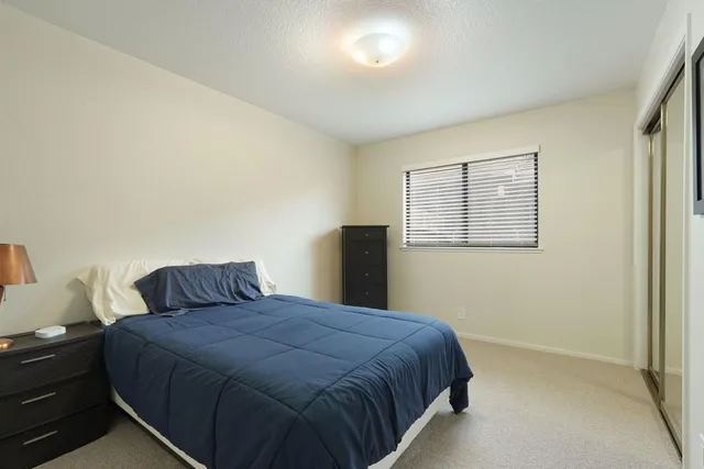 a bedroom with a bed a chandelier and a dresser