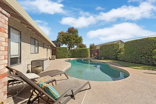 a view of a house with backyard sitting area and roof