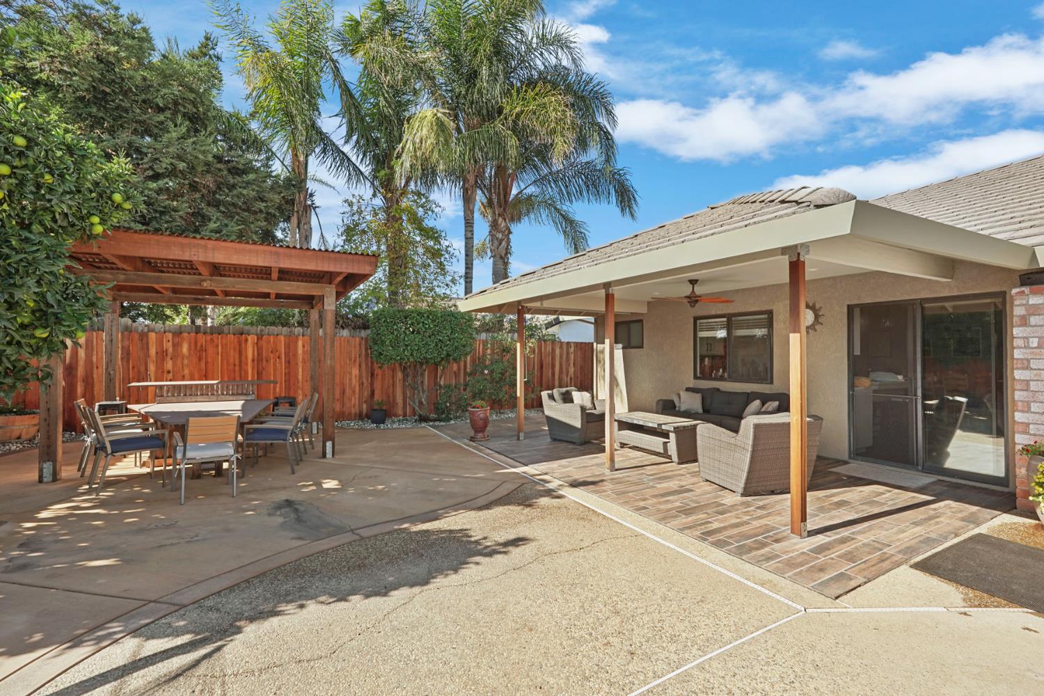 764 Adare Way Galt, CA 95632 - Photo 37 of 59 a view of a patio with table and chairs with wooden fence and plants