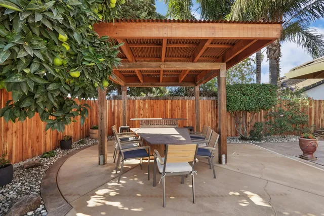 a view of a patio with dining table and chairs with wooden floor