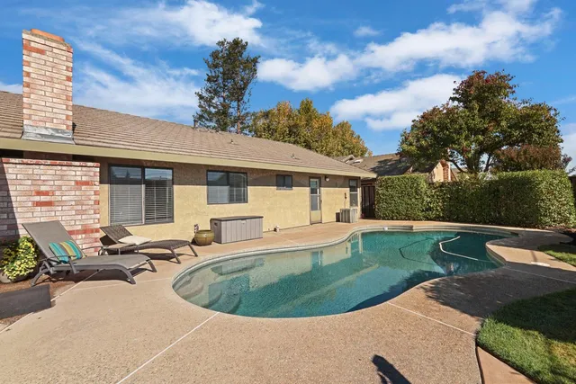 a view of a house with swimming pool and sitting area