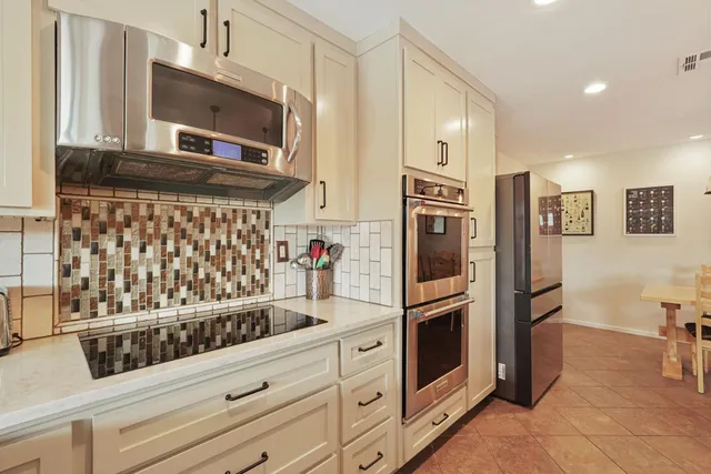 a room with stainless steel appliances kitchen island granite countertop furniture and a fireplace