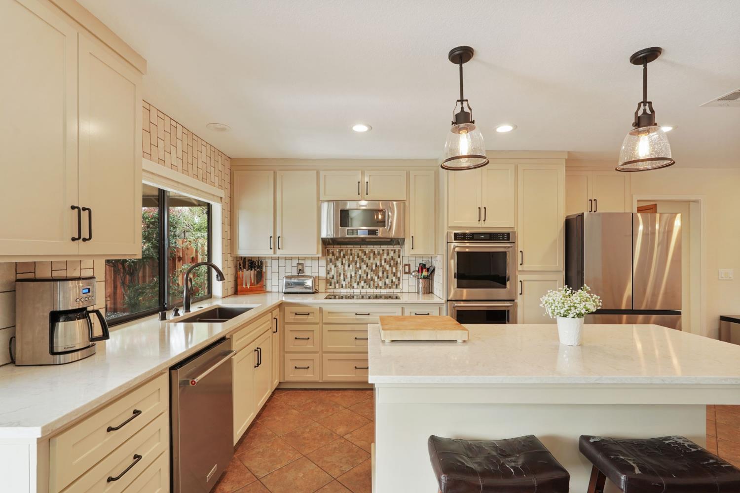 764 Adare Way Galt, CA 95632 - Photo 10 of 59 a kitchen with kitchen island granite countertop a sink cabinets and stainless steel appliances