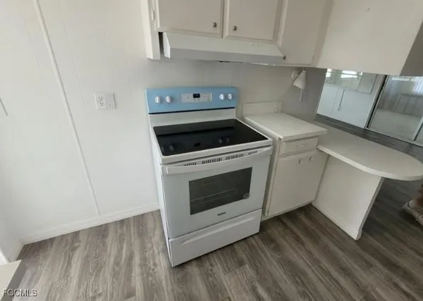 a kitchen with a stove top oven and cabinets