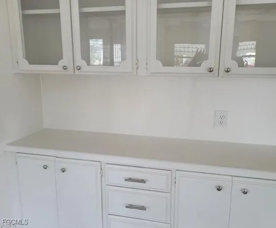 a view of white cabinets and a window