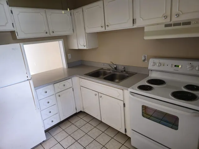 a kitchen with white cabinets and white appliances