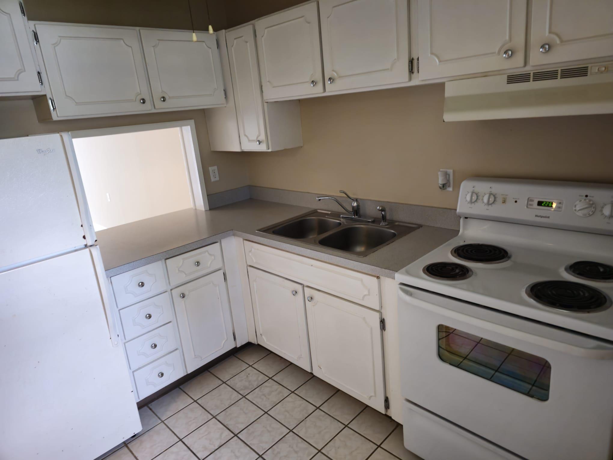a kitchen with white cabinets and white appliances