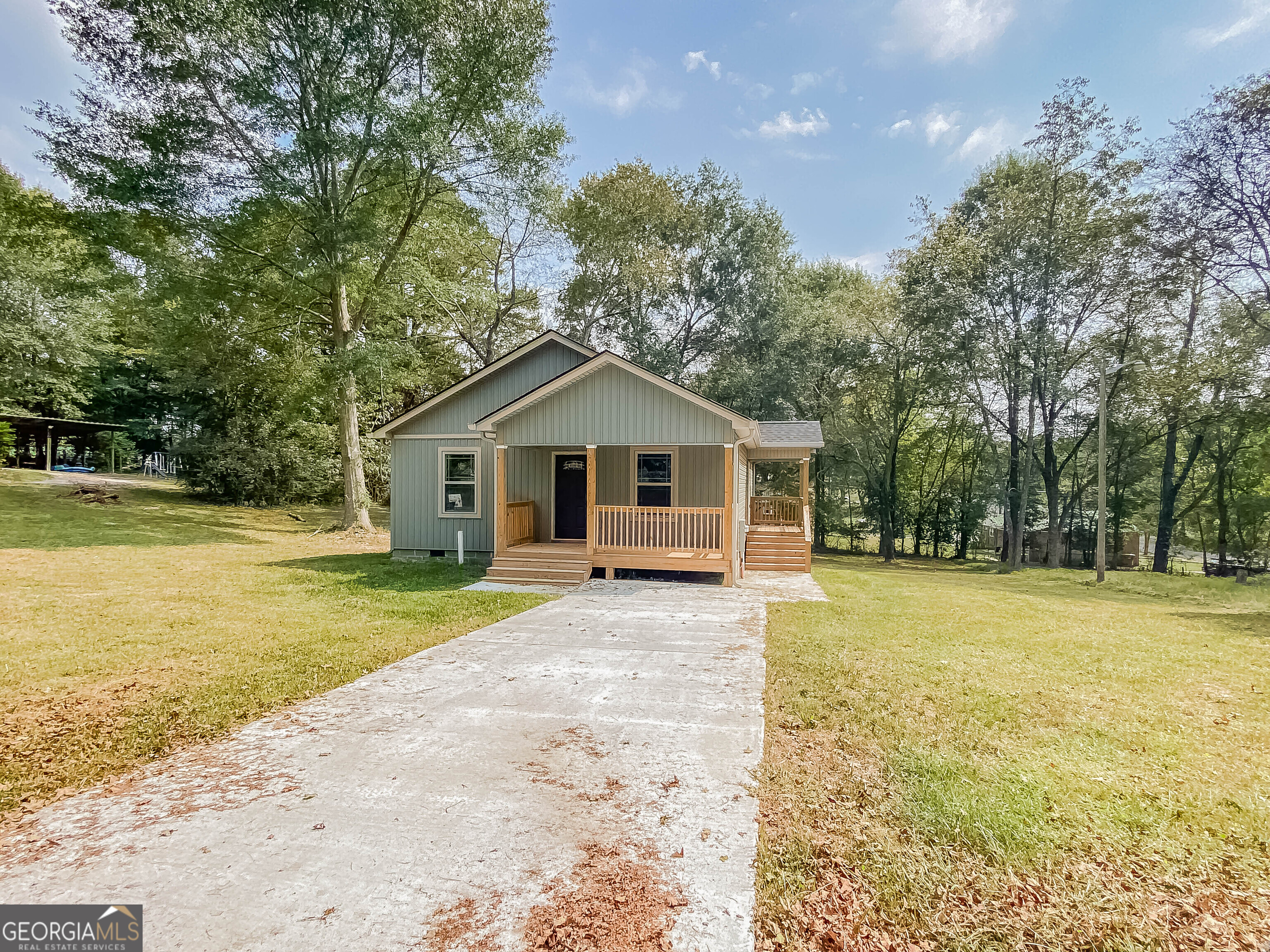 a front view of house with yard and trees in the background