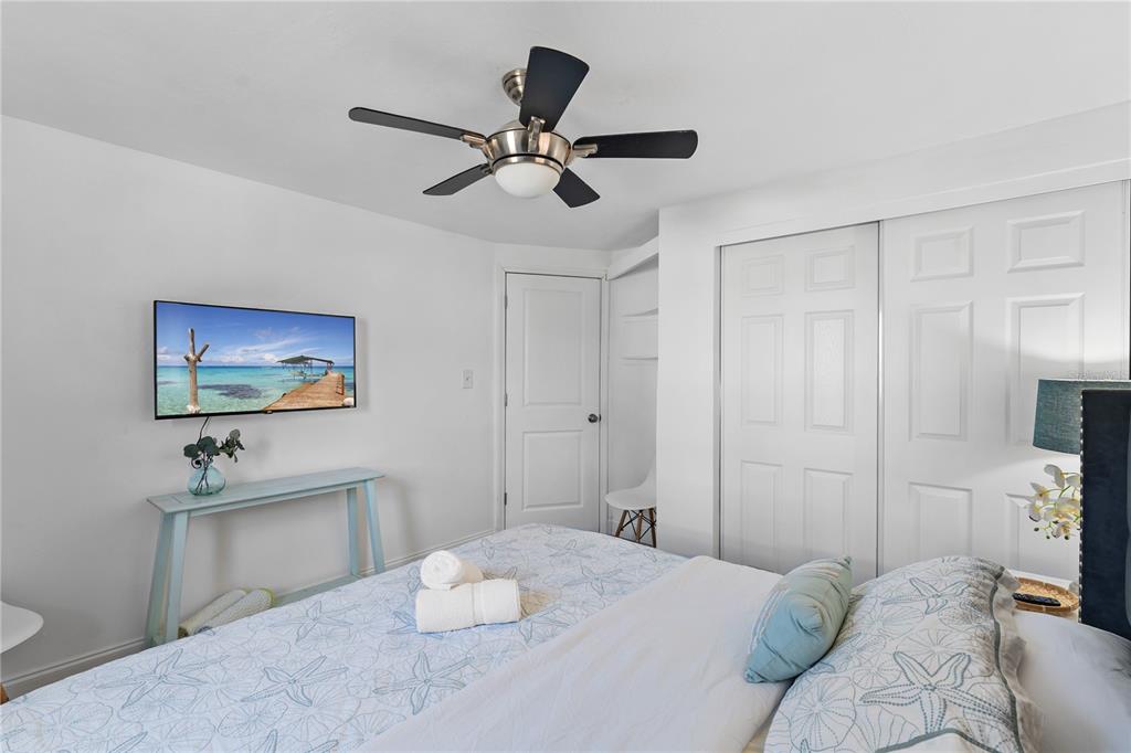 13313 2nd Street East Madeira Beach, FL 33708 - Photo 12 of 36 a bedroom with a bed and a chandelier