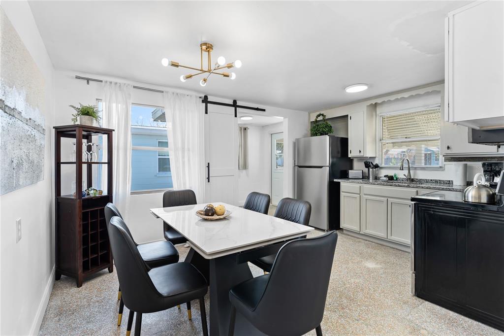13313 2nd Street East Madeira Beach, FL 33708 - Photo 13 of 36 a kitchen with refrigerator dining table and chairs