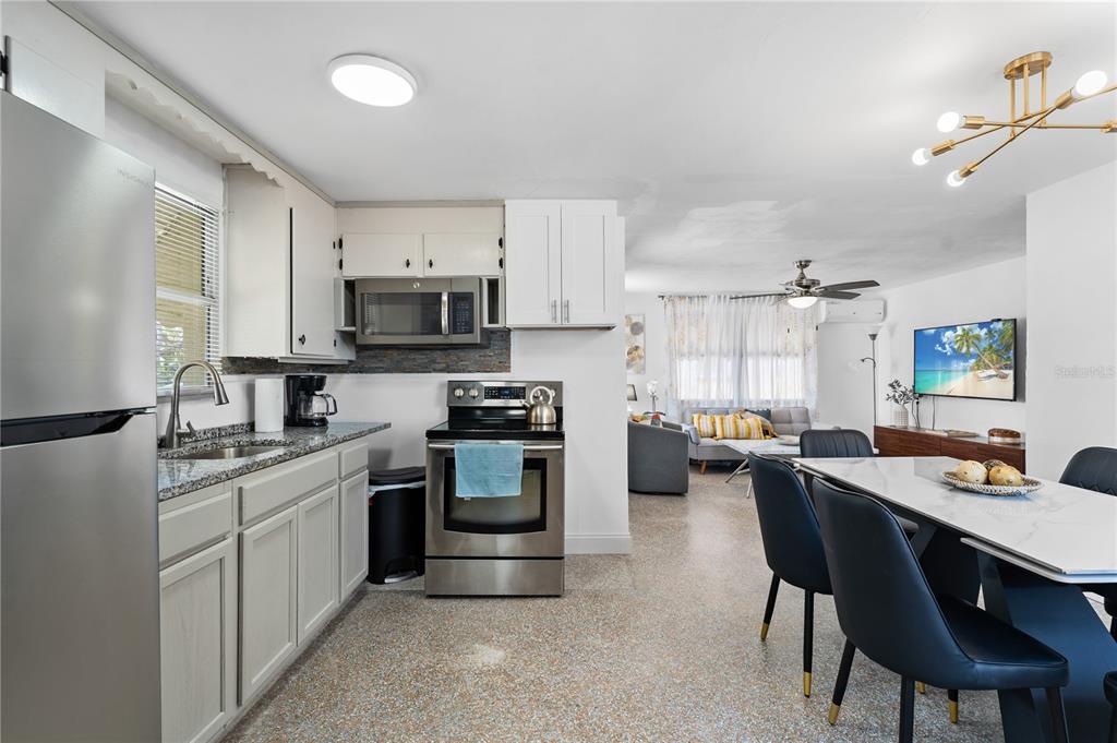 13313 2nd Street East Madeira Beach, FL 33708 - Photo 18 of 36 a kitchen with cabinets appliances and a dining table