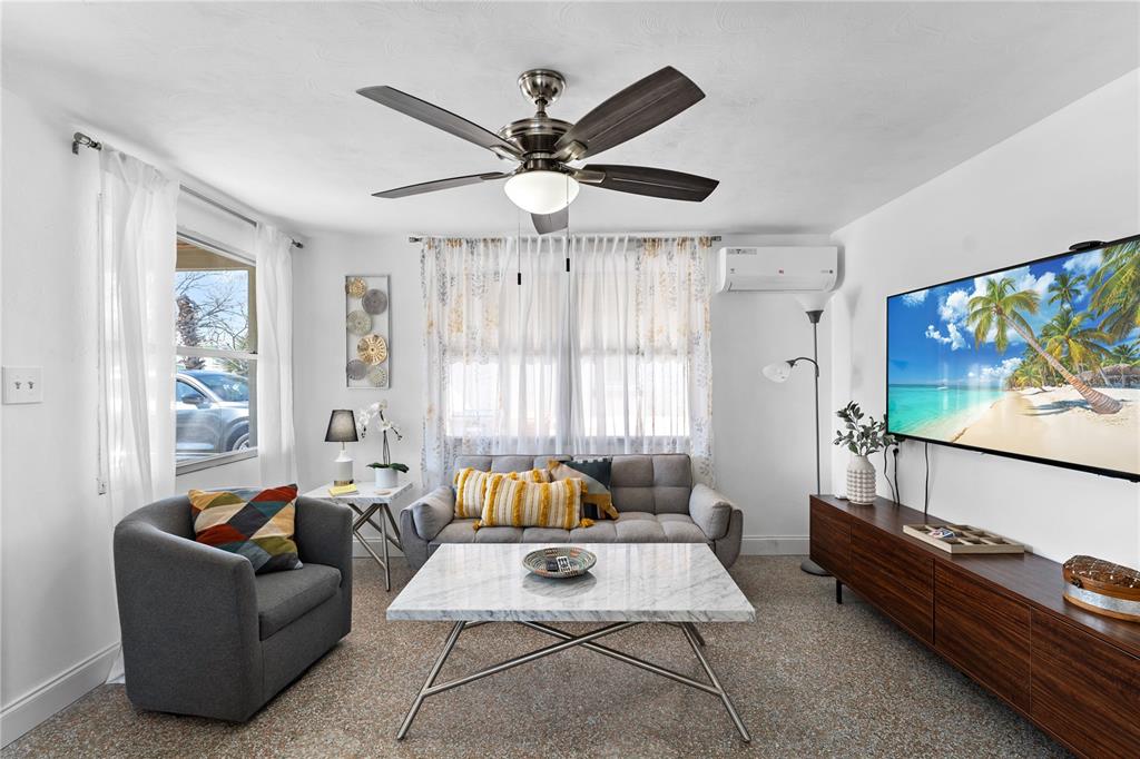 13313 2nd Street East Madeira Beach, FL 33708 - Photo 3 of 36 a living room with furniture and a flat screen tv