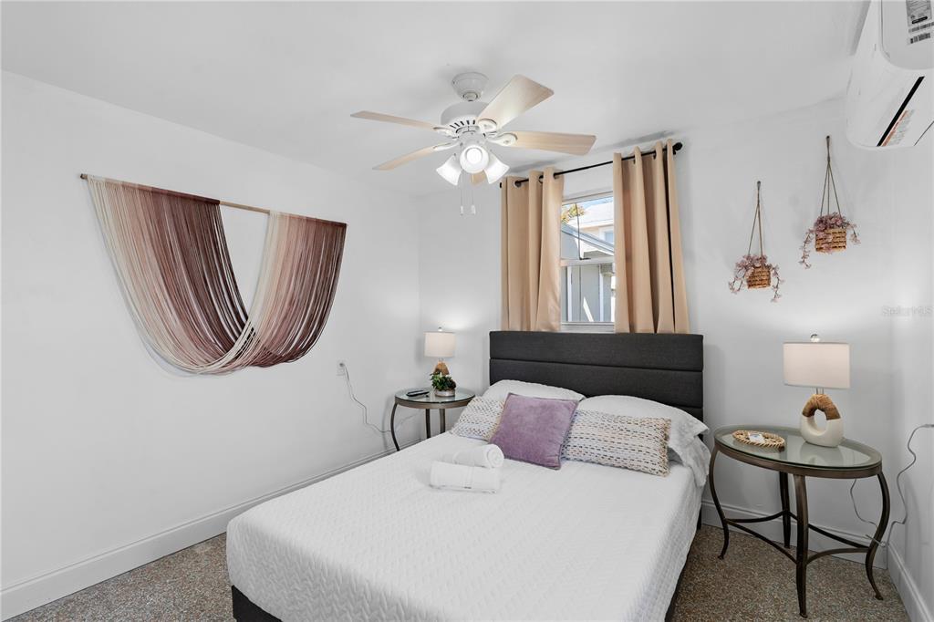 13313 2nd Street East Madeira Beach, FL 33708 - Photo 8 of 36 a bedroom with a bed and a chandelier