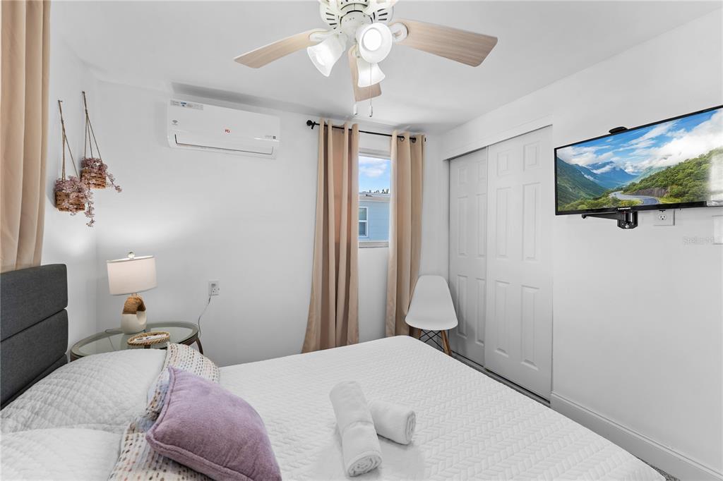 13313 2nd Street East Madeira Beach, FL 33708 - Photo 9 of 36 a bedroom with a bed and a chandelier