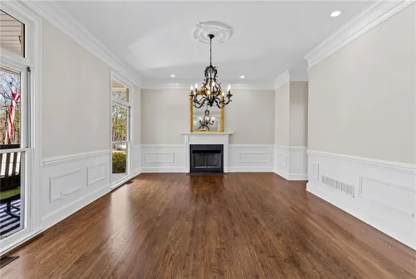 a view of a livingroom with wooden floor and a chandelier