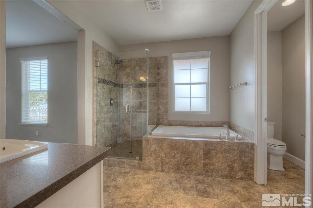 300 Mt Rose Street Reno, NV 89509 - Photo 14 of 26 a bathroom with a granite countertop bathtub sink and toilet