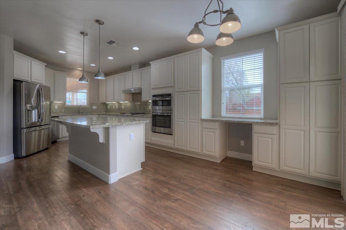 300 Mt Rose Street Reno, NV 89509 - Photo 9 of 26 a kitchen with stainless steel appliances granite countertop a refrigerator a sink dishwasher a stove and white countertops with wooden floor