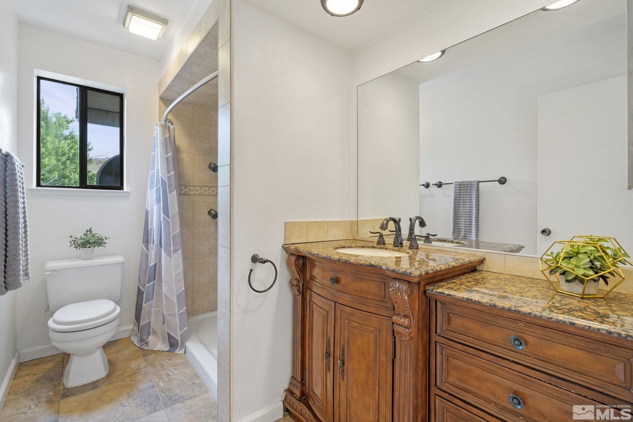 95 Cliff View Drive Reno, NV 89523 - Photo 22 of 39 a bathroom with a granite countertop toilet a sink and a mirror