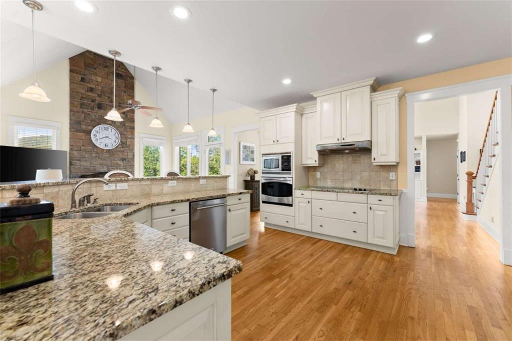 526 Orchard Drive Clarkesville, GA 30523 - Photo 13 of 81 a large kitchen with stainless steel appliances granite countertop a lot of counter space and wooden floors