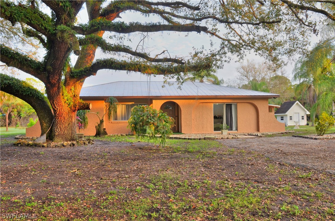 a view of a house with a tree and a yard